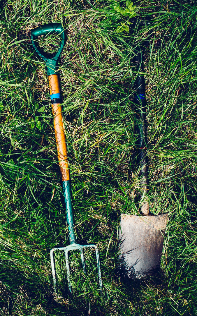 Garden fork and shovel in grass