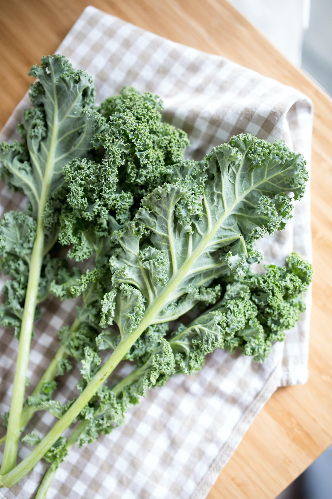 Growing Kale: curly kale leaves on a brown and white gingham tea towel